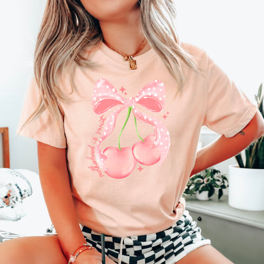 Motherhood Is Sweet Cherries and Bow Graphic T-Shirt | Cute Coquette Mama Tee | Trendy Mom Unisex Shirt | Sweet Motherhood Apparel